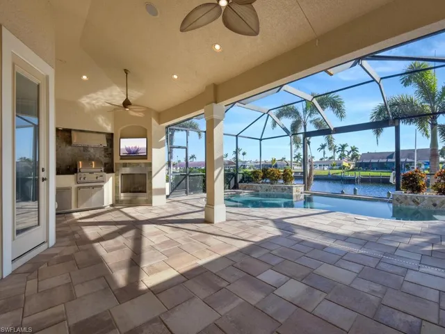 View of patio / terrace with a lanai, ceiling fan, area for grilling, grilling area, and pool water feature
