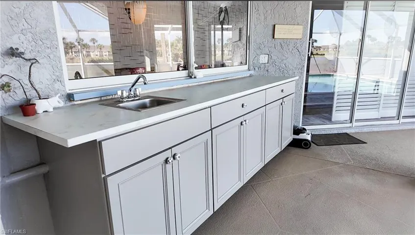 Outdoor cabinetry, countertop and sink under pass through to kitchen