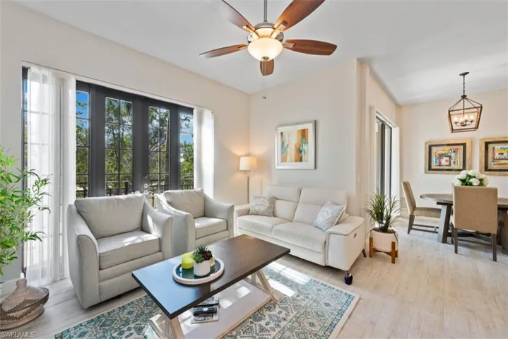 Living room with light wood-style floors, a ceiling fan, and a chandelier