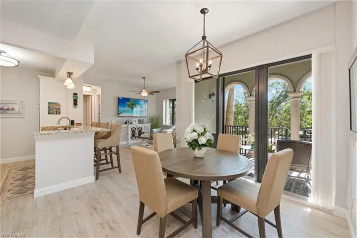 Dining space with a chandelier, a ceiling fan, and light wood-style floors