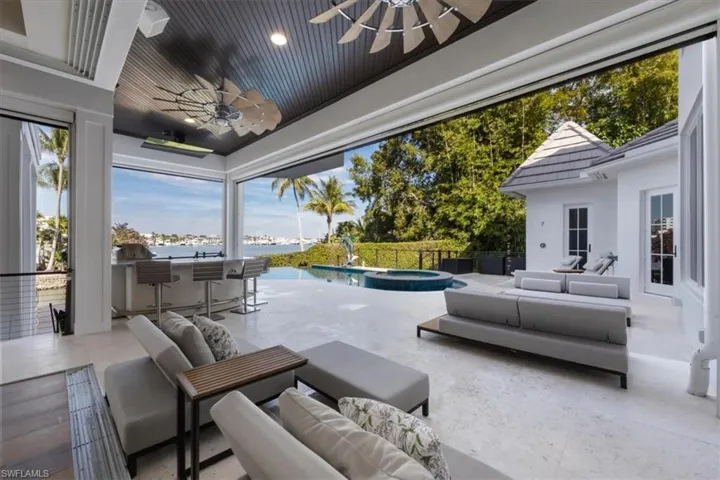 View of patio with an outdoor hangout area, ceiling fan, a water view, and a pool with connected hot tub