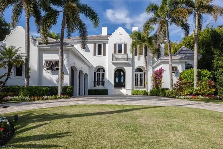 Mediterranean / spanish house featuring french doors, a front yard, a balcony, and stucco siding
