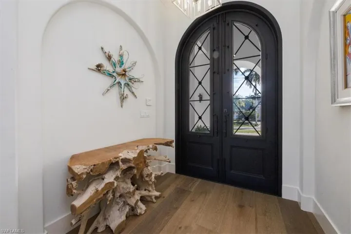 Foyer entrance featuring arched walkways, wood finished floors, and french doors