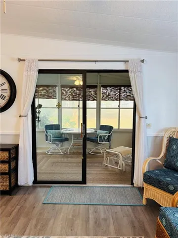 Doorway to outside featuring wood finished floors, healthy amount of natural light, and a textured ceiling