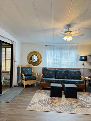 Living area featuring wood finished floors, ceiling fan, and a textured ceiling