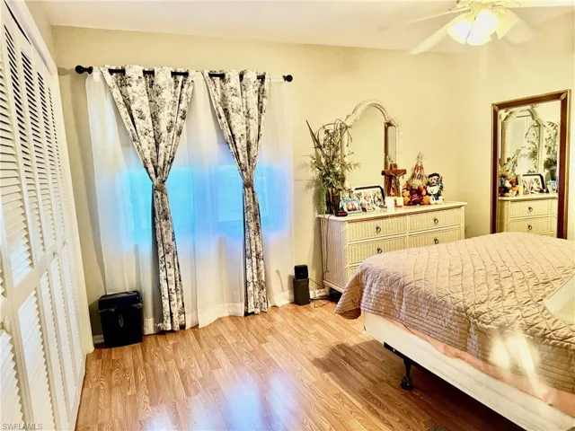 Bedroom with wood finished floors, a closet, and a ceiling fan