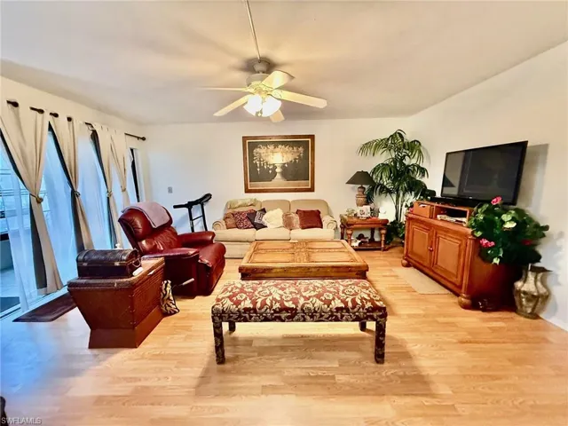 Living room with light wood finished floors and a ceiling fan