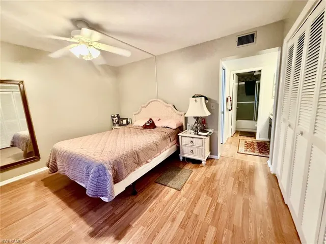 Bedroom with light wood-style flooring, a ceiling fan, and a closet