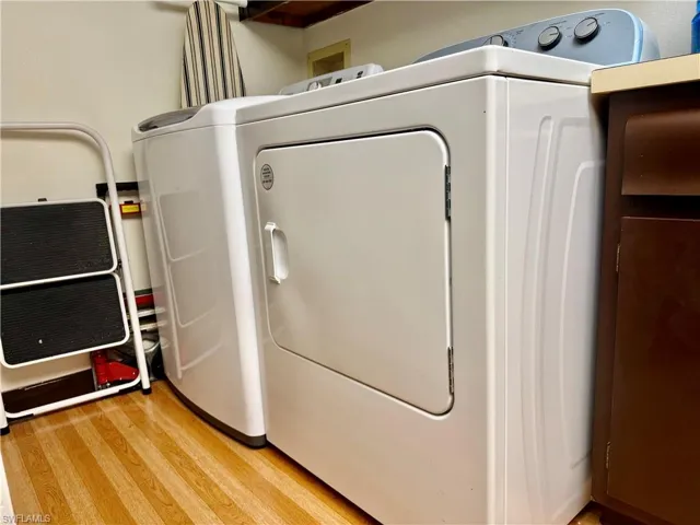 Laundry area featuring light wood-style floors and independent washer and dryer