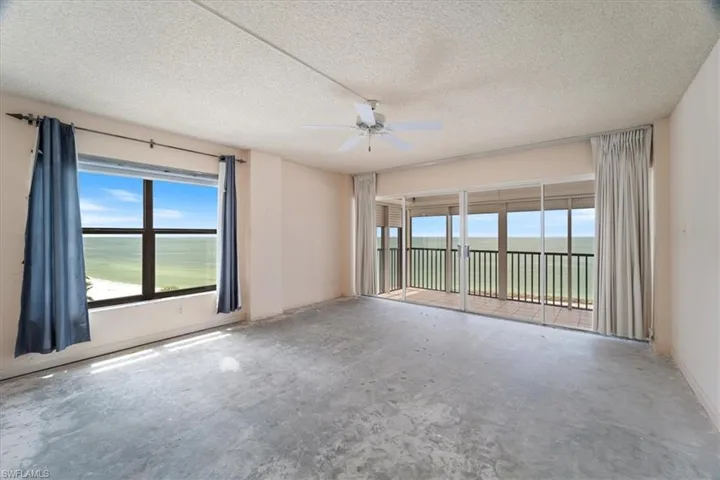Spare room featuring a textured ceiling, a water view, ceiling fan, and unfinished concrete flooring