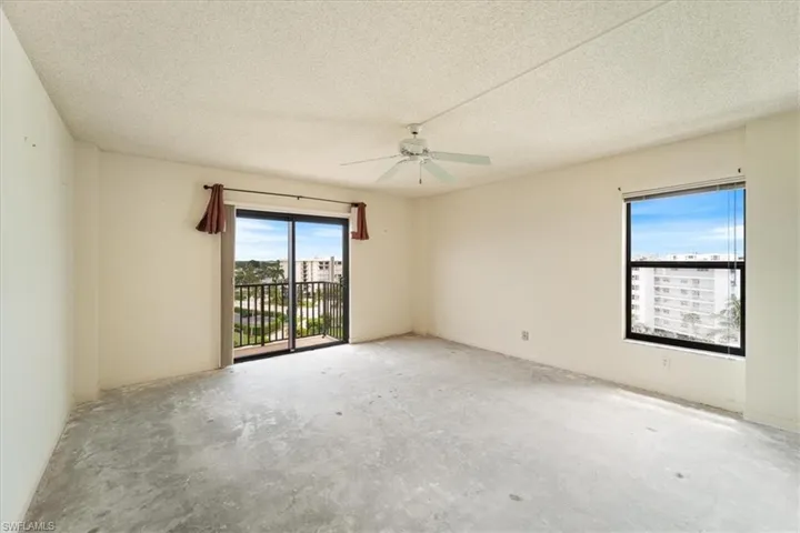 Empty room featuring a textured ceiling, ceiling fan, and unfinished concrete flooring