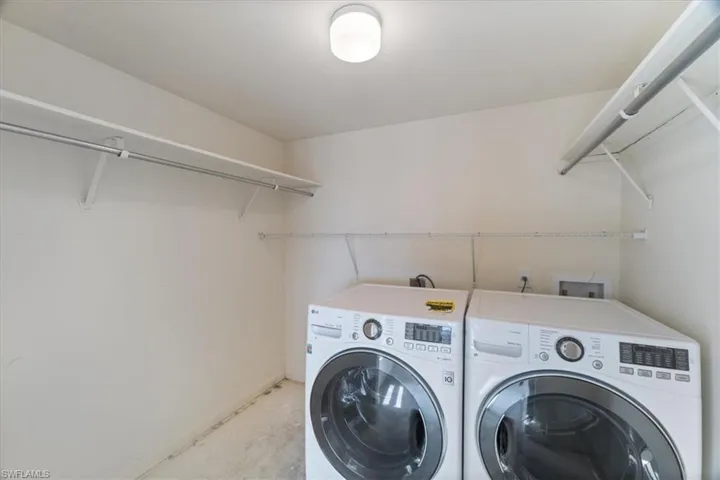 Laundry room featuring washing machine and clothes dryer and baseboards