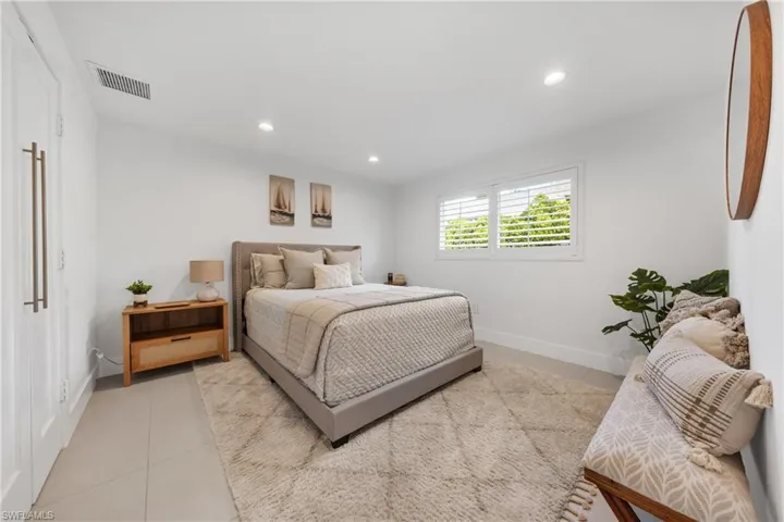 Bedroom with light tile patterned floors and recessed lighting