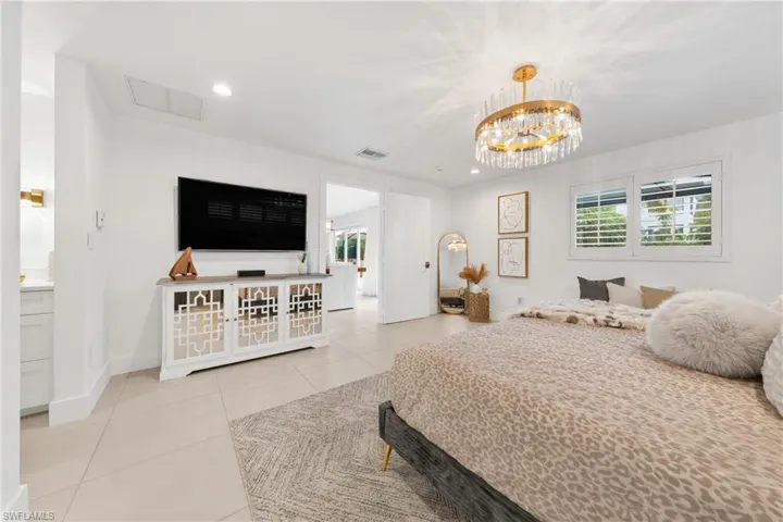 Bedroom with recessed lighting, light tile patterned floors, and a chandelier