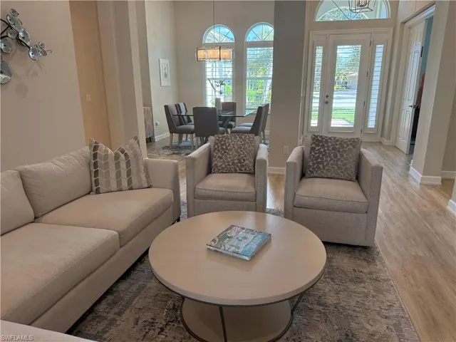 Living room featuring wood finished floors, a chandelier, and a high ceiling