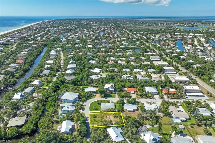 Aerial perspective of suburban area featuring a nearby body of water and property boundaries highlighted