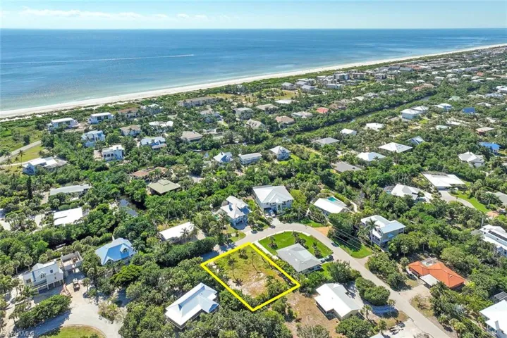 Aerial perspective of suburban area with expansive beach and property parcel outlined