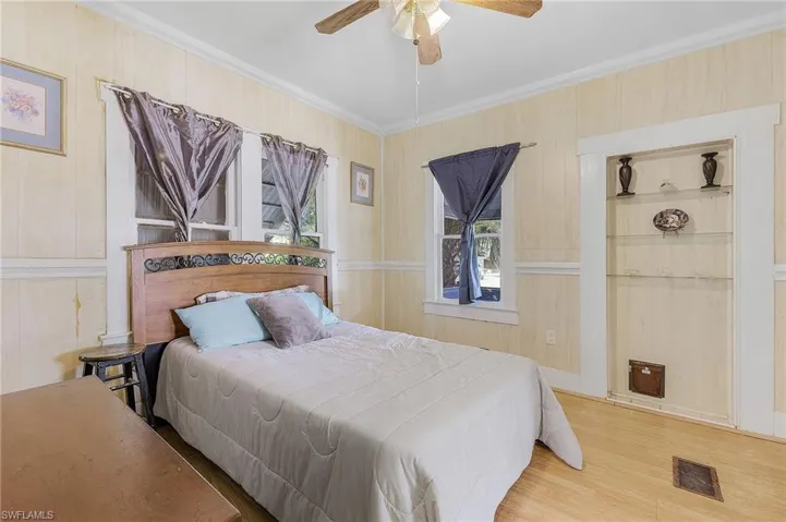 Bedroom with ceiling fan, hardwood / wood-style flooring, and crown molding