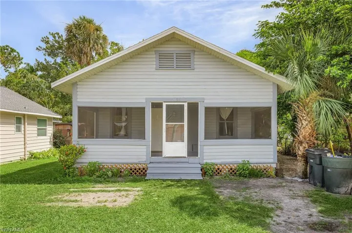 View of front of home featuring a sunroom and a front lawn