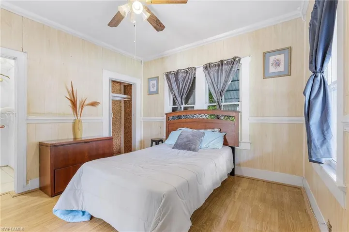 Bedroom featuring ceiling fan, light hardwood / wood-style flooring, and crown molding