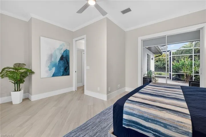 Bedroom with light wood-type flooring, access to exterior, ornamental molding, and a ceiling fan