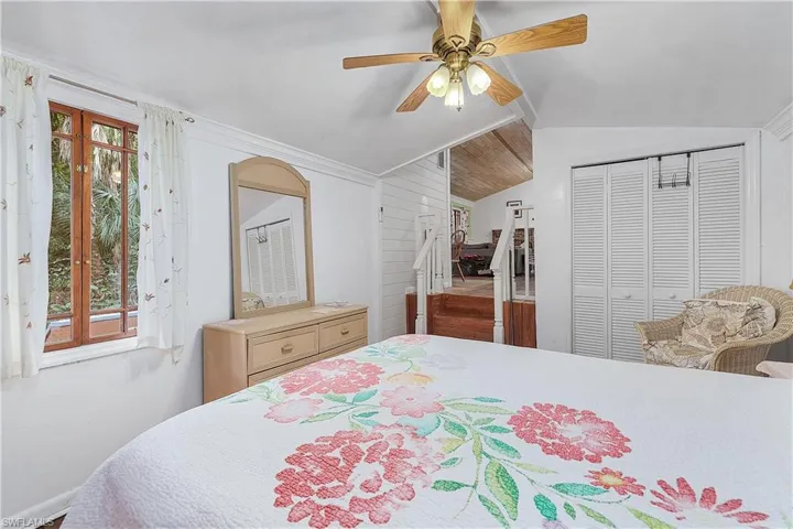 Bedroom featuring ceiling fan, a closet, lofted ceiling, and multiple windows