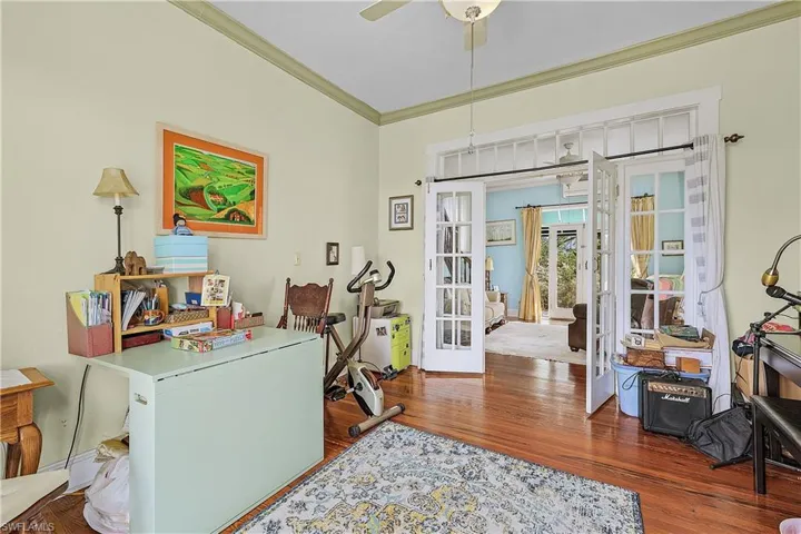 Office area with crown molding, hardwood / wood-style floors, ceiling fan, and french doors