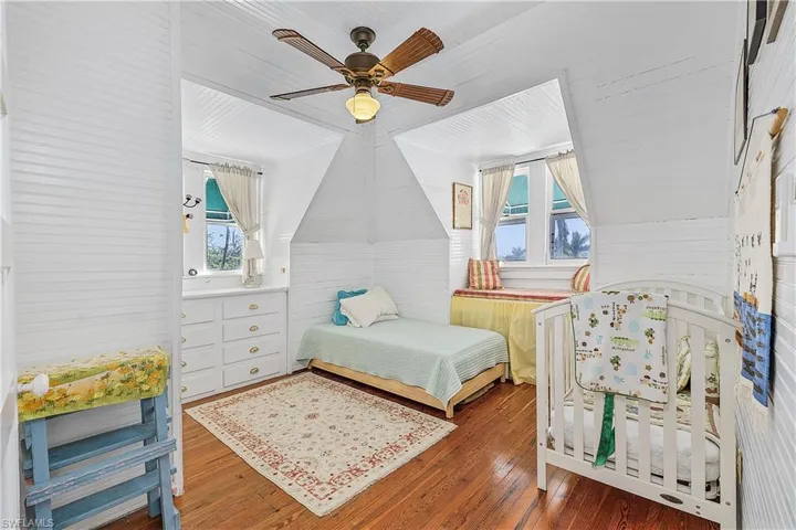 Bedroom featuring ceiling fan, dark hardwood / wood-style floors, and vaulted ceiling