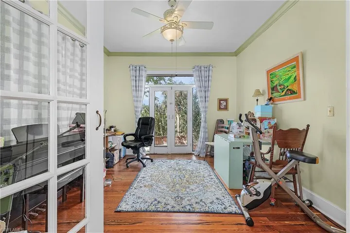 Office with crown molding, french doors, ceiling fan, and hardwood / wood-style flooring