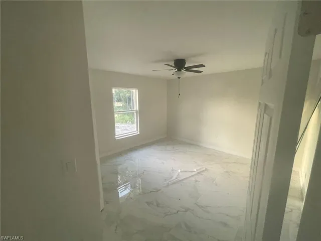 Tiled empty room featuring ceiling fan