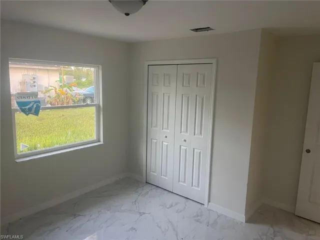 Unfurnished bedroom with a closet and light tile patterned floors