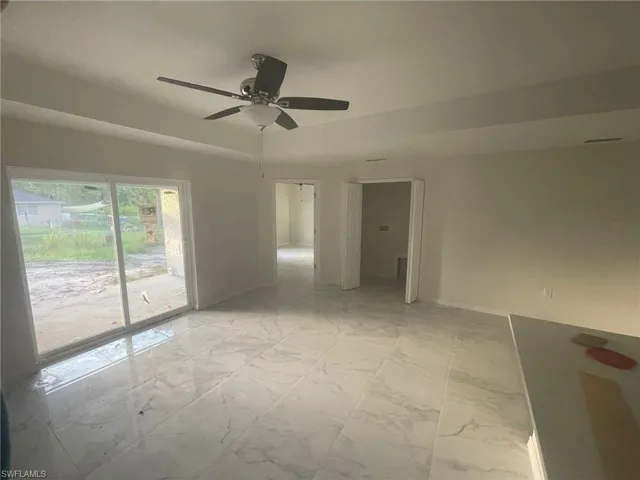 Tiled empty room featuring ceiling fan