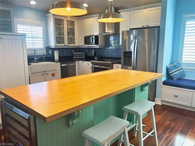 Kitchen with wine cooler, pendant lighting, a breakfast bar, and appliances with stainless steel finishes (Photo may be virtually enhanced)