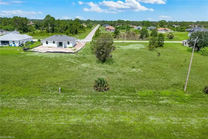 Spacious green lot featuring an adjacent new construction home