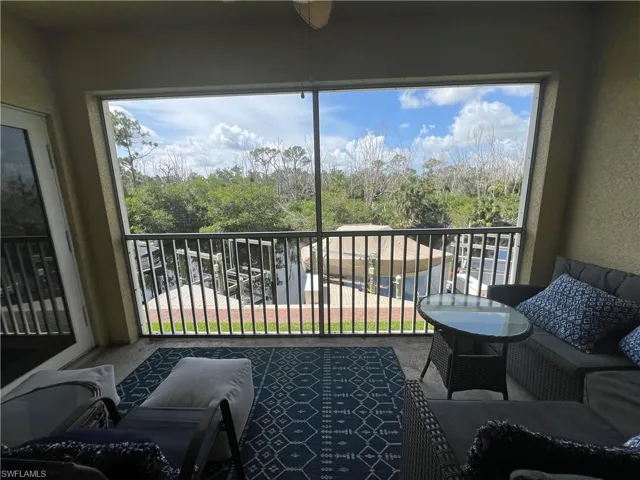 Balcony featuring view of wooded area