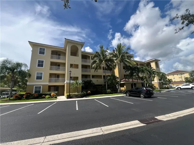 View of building exterior with uncovered parking