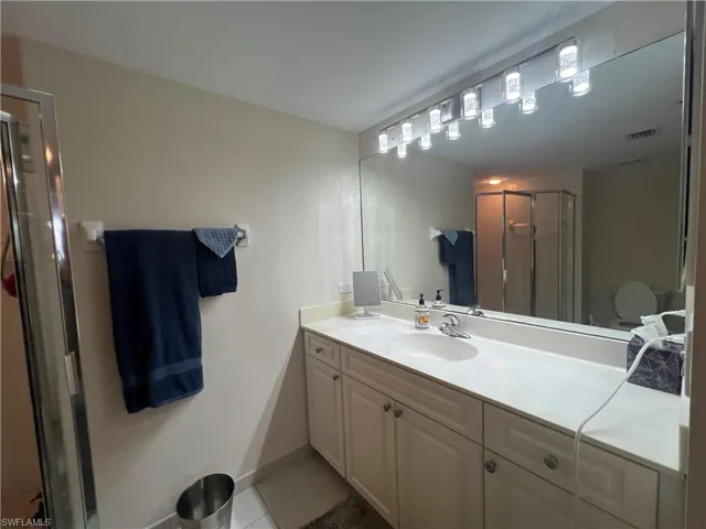Bathroom featuring vanity, a stall shower, and tile patterned floors