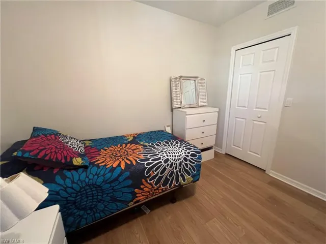 Bedroom with wood finished floors and baseboards