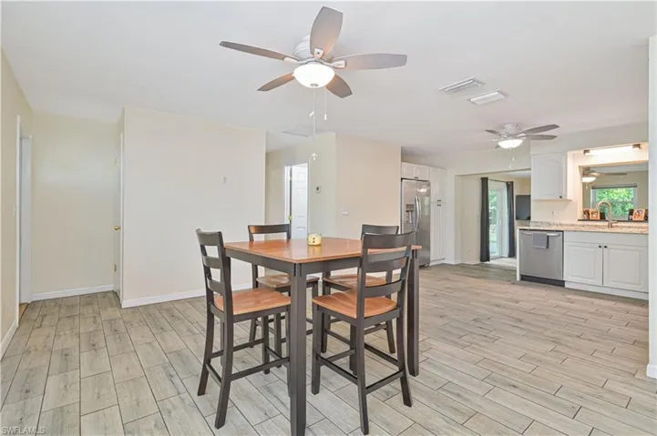 Open-concept living space with wood-finish tile flooring, recessed lighting, and ceiling fans