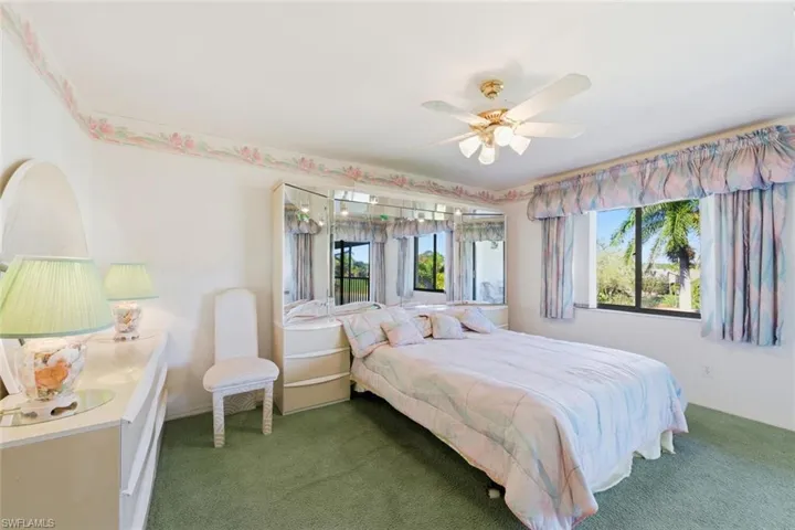 Bedroom featuring carpet, multiple windows, and ceiling fan
