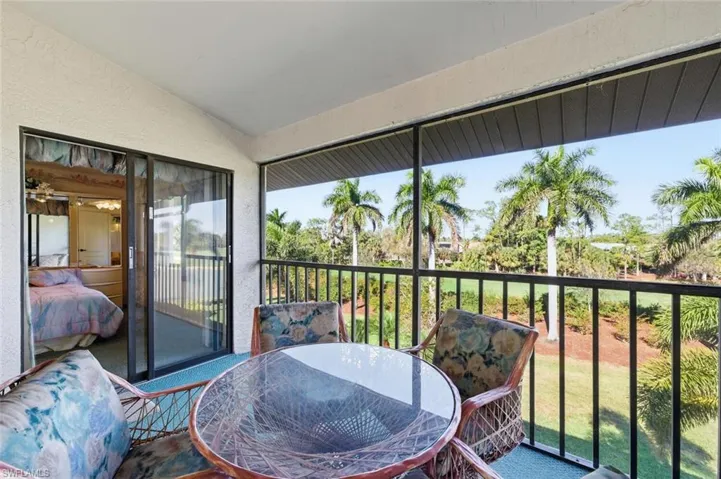 Sunroom / solarium with a balcony, outdoor dining space, and lofted ceiling