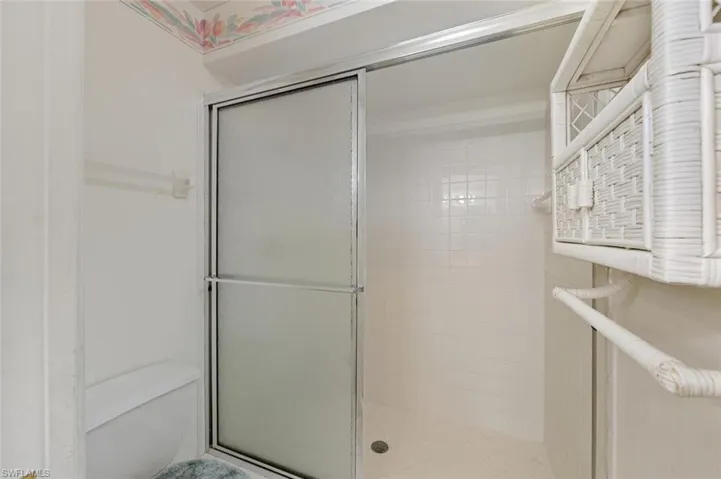 Full bath with toilet and a shower stall