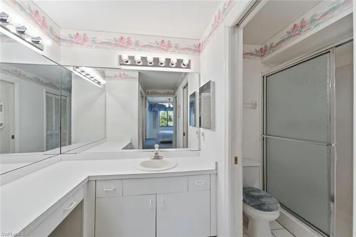 Bathroom with vanity, a shower stall, ensuite bathroom, and light tile patterned flooring