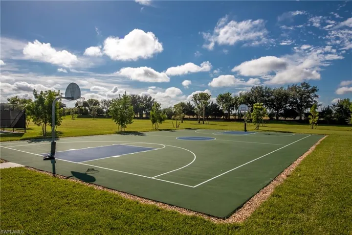 View of basketball court featuring a lawn and community basketball court