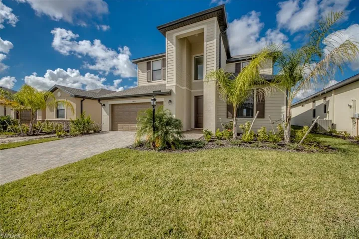 View of front of house featuring a front lawn, a garage, and decorative driveway