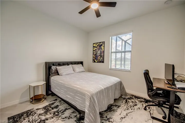 Bedroom featuring a ceiling fan, a desk, and light tile patterned floors