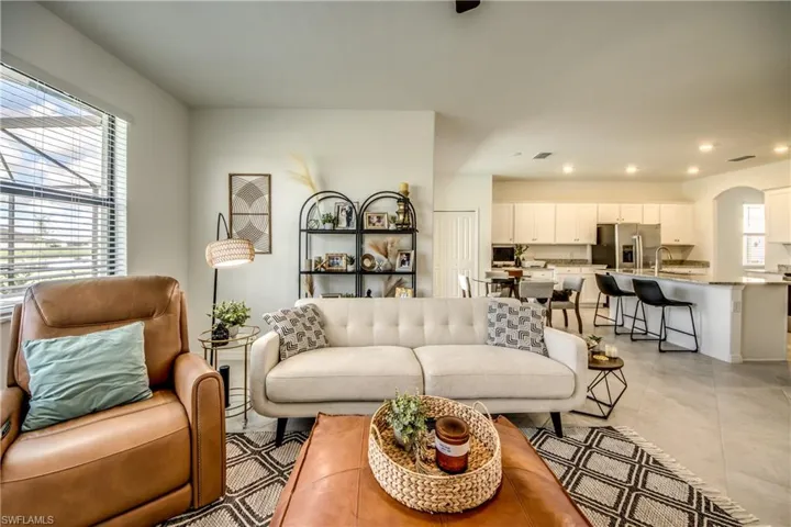 Living area featuring arched walkways, recessed lighting, and light tile patterned floors