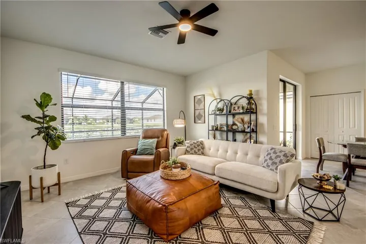 Living room featuring plenty of natural light, a ceiling fan, and light tile patterned flooring