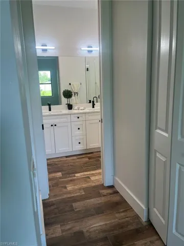 Bathroom featuring double vanity and dark wood-style floors