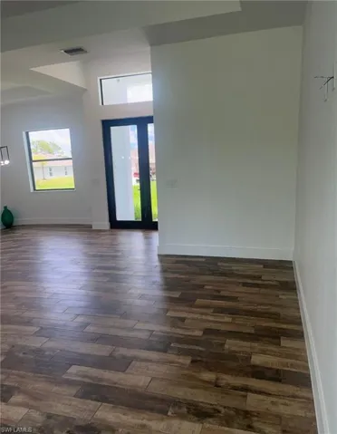 Foyer entrance with healthy amount of natural light and dark wood-style floors